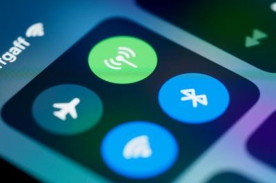 visualys- Eine Nahaufnahme eines Smartphone-Bildschirms, auf dem das Kontrollzentrum mit Symbolen für Flugzeugmodus, Wi-Fi, Bluetooth und drahtlose Verbindungen angezeigt wird, von denen einige blau und grün hervorgehoben sind.