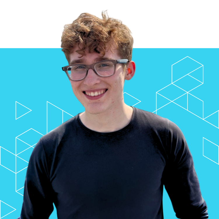 A smiling young person with curly brown hair and glasses, wearing a black long-sleeve shirt, stands in front of a blue background with geometric white line designs.