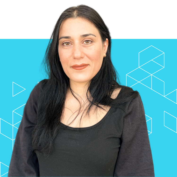 A woman with long black hair and a black shirt stands in front of a blue background with white geometric shapes. She is looking at the camera with a neutral expression.