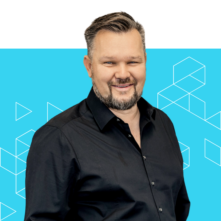 A smiling man with short, styled hair and a beard, wearing a black shirt, stands in front of a blue background with geometric line patterns.